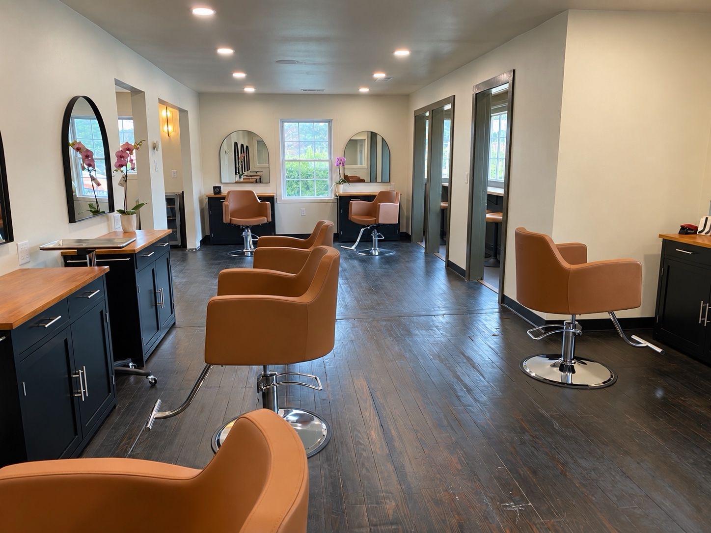 The styling floor, with stations, arched mirrors, and wood floors